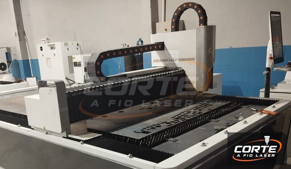 Máquina de corte a laser: pórtico, cabeçote e esteira porta-cabos sobre a mesa de corte
